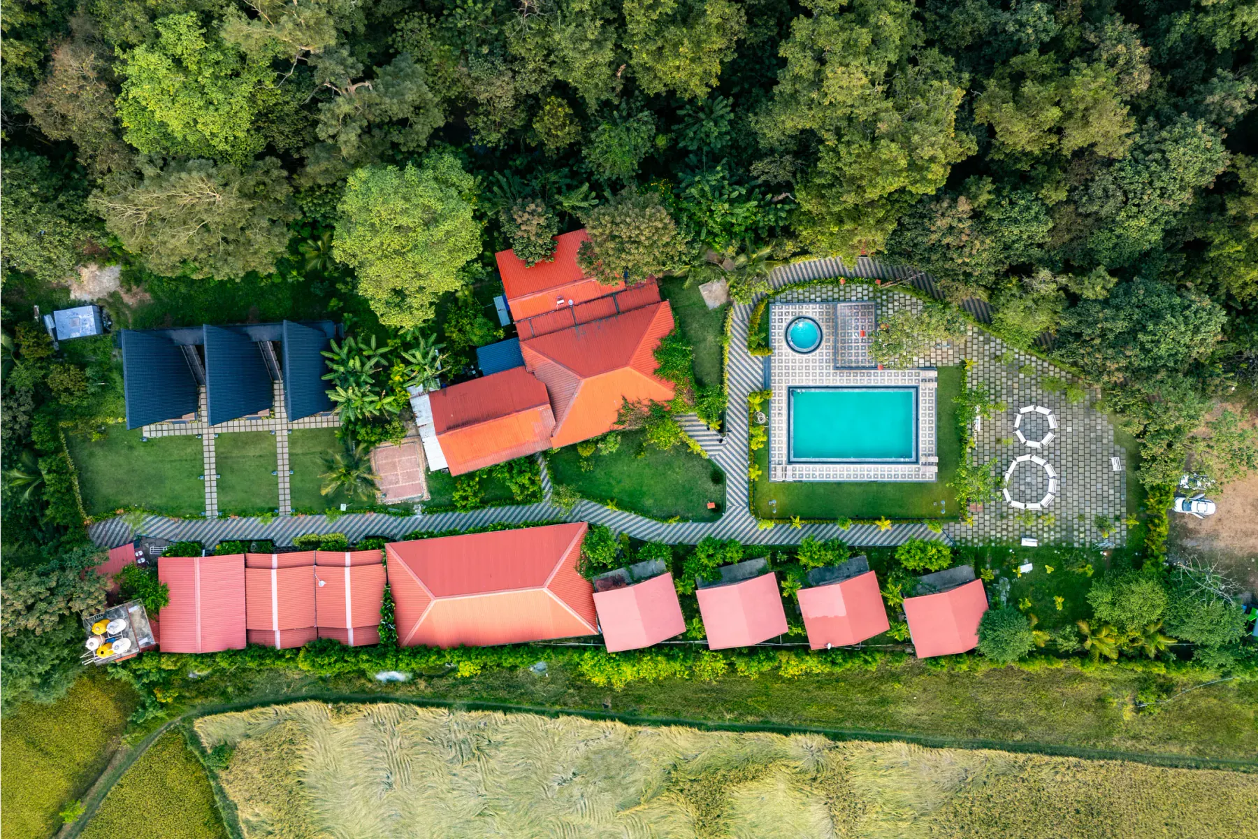 Aerial view of Jungle Edge with A-frame cottages, pools, rooms and garden paths